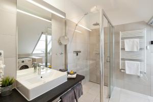 a white bathroom with a sink and a shower at Am Horizont No 2 Fewo für 4 Pers, 2 Schlafzimmer, Südbalkon, W-LAN, Homeoffice geeignet, Parkplatz in Zingst