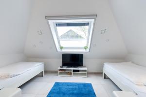 a room with two beds and a window at Am Horizont 2 stilvoll mitten im Herzen von Zingst nahe Seebrücke und Strand Parkplatz und WLAN inklusiv in Zingst