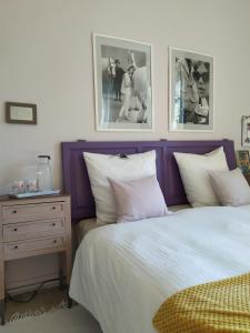 ein Schlafzimmer mit einem Bett, einem Nachttisch und Bildern in der Unterkunft Envie de Sud in Vauvert