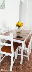 een witte tafel en stoelen met een vaas met bloemen erop bij tranquilidad en el centro de la ciudad in Málaga