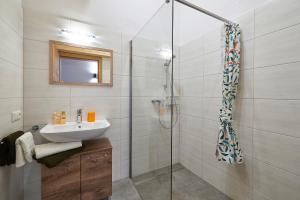 La salle de bains est pourvue d'un lavabo et d'une douche. dans l'établissement Ferienhaus Rohrmoos Maria Alm, à Maria Alm