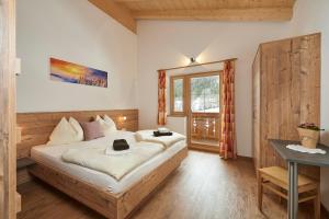 a bedroom with a bed and a window at Ferienhaus Rohrmoos Maria Alm in Maria Alm am Steinernen Meer
