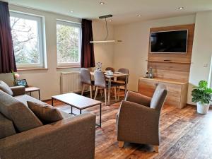 a living room with a table and a dining room at Hotel & Chalets Herrihof in Todtnauberg