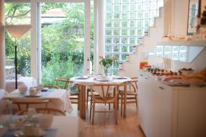 a kitchen with tables and chairs and a large window at Hotel Van Bunnen in Knokke-Heist