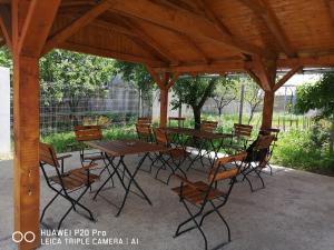 a group of tables and chairs under a pavilion at Casa Hortensia in Tăşnad