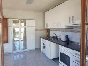 a kitchen with white cabinets and a washer and dryer at La Casa del Valle in Soncillo