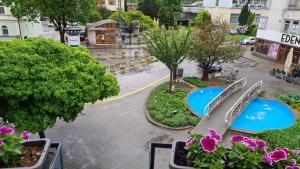 - une vue sur une rue avec un banc et des fleurs dans l'établissement City Hotel, à Piešťany