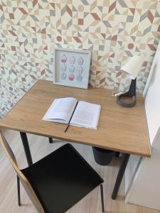 a desk with a book and a lamp and a lamp at Rooms4Less in Gdańsk