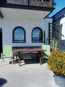un tavolo da picnic in legno e 2 sedie di fronte a una casa di Alpensicht a Schladming