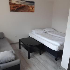 1 dormitorio con cama, mesa y sofá en Pueblo Pokoje, en Stegna