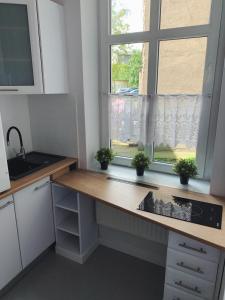 a kitchen with a counter and a window at Rooms4Less in Gdańsk