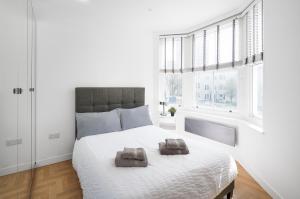 a bedroom with a large bed with two towels on it at Clarence Square in Brighton & Hove