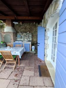 a patio with a table and chairs and a blue door at Apartment Valun 60 in Valun