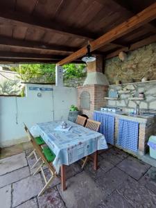 a table and chairs on a patio with a stove at Apartment Valun 60 in Valun +18 photos