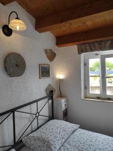 a bedroom with a bed and a window at Apartment Valun 60 in Valun