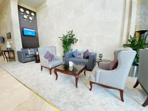 a lobby with couches and chairs and a tv at Mercure Corniche Al Khobar in Al Khobar