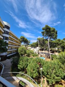 a view from the balcony of a building with a garden at Apartamento con piscina a unos metros de la playa in Moraira