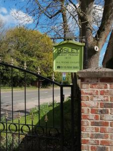 una señal para una casa al lado de una valla en Risley Guest House en Risley