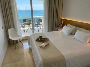 a bedroom with a large bed with a view of the ocean at Mediterraneo Sitges in Sitges