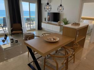 a living room with a dining table and a room with the ocean at Mediterraneo Sitges in Sitges