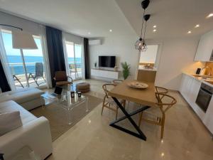 a living room with a couch and a table with chairs at Mediterraneo Sitges in Sitges