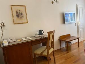 a wooden desk with a chair and a telephone at Hotel Deutscher Kaiser in Nuremberg