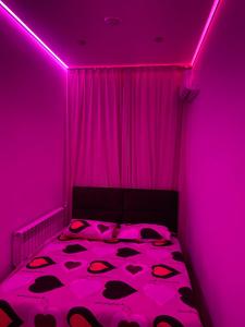a pink room with a bed with a pink ceiling at Olesi Gonhara in Dnipro