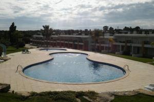 - une grande piscine dans une cour avec un bâtiment dans l'établissement Apartamento Albufeira, à Albufeira