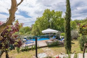 un giardino con terrazza e piscina di Casa vacanze San Giusto a Sovicille