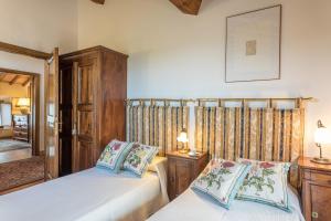 a bedroom with two beds and a mirror at Casa vacanze San Giusto in Sovicille