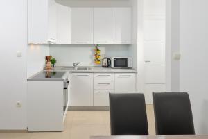 a white kitchen with a sink and a microwave at Villa Ivano in Makarska