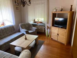 ein Wohnzimmer mit einem Sofa und einem TV in der Unterkunft Kleines Ferienhaus Nicole in Piesport