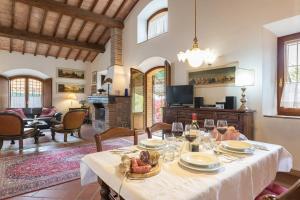 a dining room with a table and a living room at Casa vacanze San Giusto in Sovicille