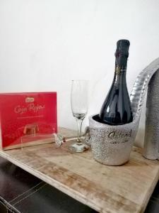 una botella de vino y una copa en una tabla de cortar en El escondite de Martina, Casa Rural Romántica, en Setenil