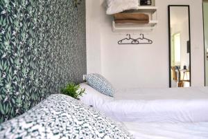 a bedroom with two beds and a wall with wallpaper at Hôtel le Thurot in Dijon