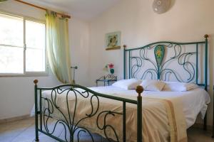 a bedroom with a bed with a metal frame at Santu Juanne -Ammentos Posada- a due passi dalla spiaggia in San Giovanni