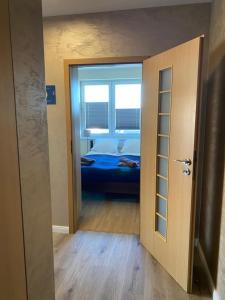 een open deur naar een slaapkamer met een bed bij Apartament Zielone Tarasy 9C in Kołobrzeg