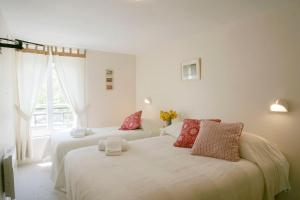 1 dormitorio con 2 camas y ventana en Hotel Des Arts en Puybrun