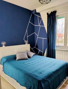 a bedroom with a blue wall and a bed at Annemarie B&B in Marina di Pisa