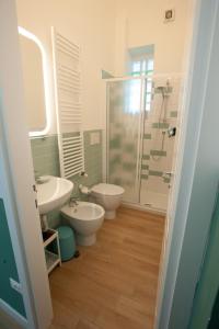 a bathroom with two toilets and a sink and a shower at Annemarie B&B in Marina di Pisa