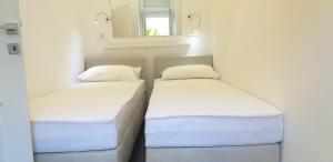 two twin beds in a room with a window at Luxurios and historic apartment "Shine" - right on the Main Square in Zagreb