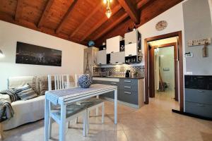 a kitchen and living room with a table and a couch at IL TORCHIO rooftop apartment with wide terrace in Sirmione