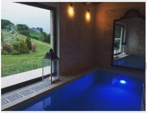 塞尼加利亞的住宿－Country House Martines Club Resort & Mandalay SPA，窗户客房内的大蓝色浴缸