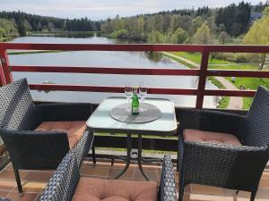 einen Tisch mit zwei Gläsern Wein auf dem Balkon in der Unterkunft Harz Dream - Vier Jahreszeiten in Hahnenklee-Bockswiese