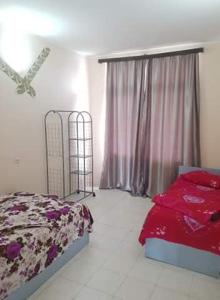 a bedroom with a bed with red sheets and a window at Old House Hotel in Ureki