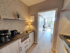 a kitchen with white cabinets and a counter top at Harz Dream - Vier Jahreszeiten in Hahnenklee-Bockswiese