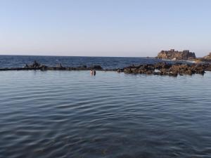 a body of water with a group of people in the water at Pozo de las Calcosas - El Hierro in Pozo de las Calcosas