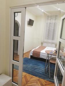 um quarto com uma cama, uma mesa e uma janela em Baross-hat 4 em Szolnok