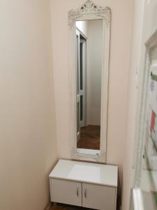uma casa de banho com uma cómoda branca e um espelho em Baross-hat 4 em Szolnok