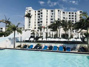 a resort with a swimming pool with chairs and a building at Umhlanga Beach Front 4 Sleeper in Durban